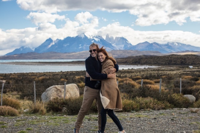 Photo of two people hugging on the Hotel Las Torres grounds with mountains in background