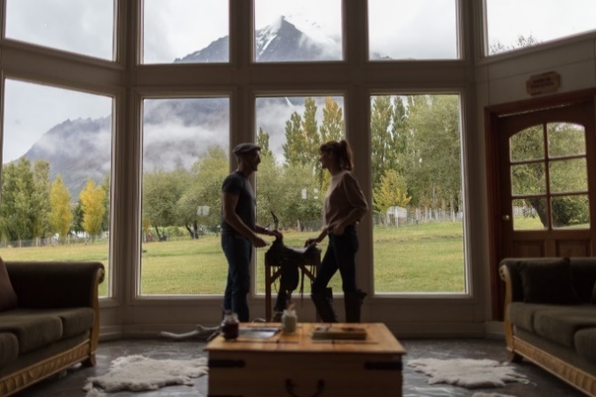 Photo of two people in a sun room at the Hotel Las Torres grounds with mountains in background