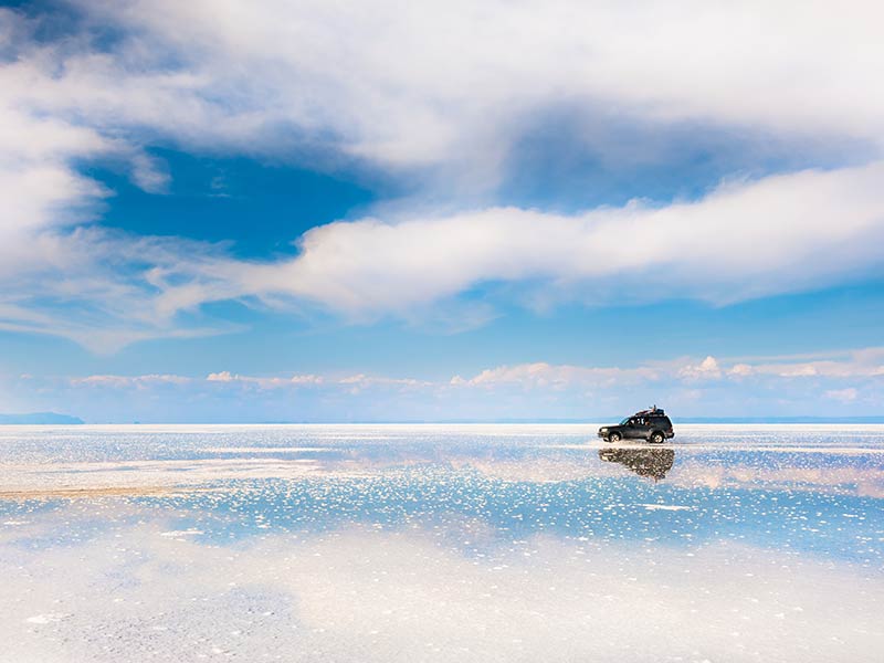 Photo of an SUV driving on salt flats in San Pedro de Atacama